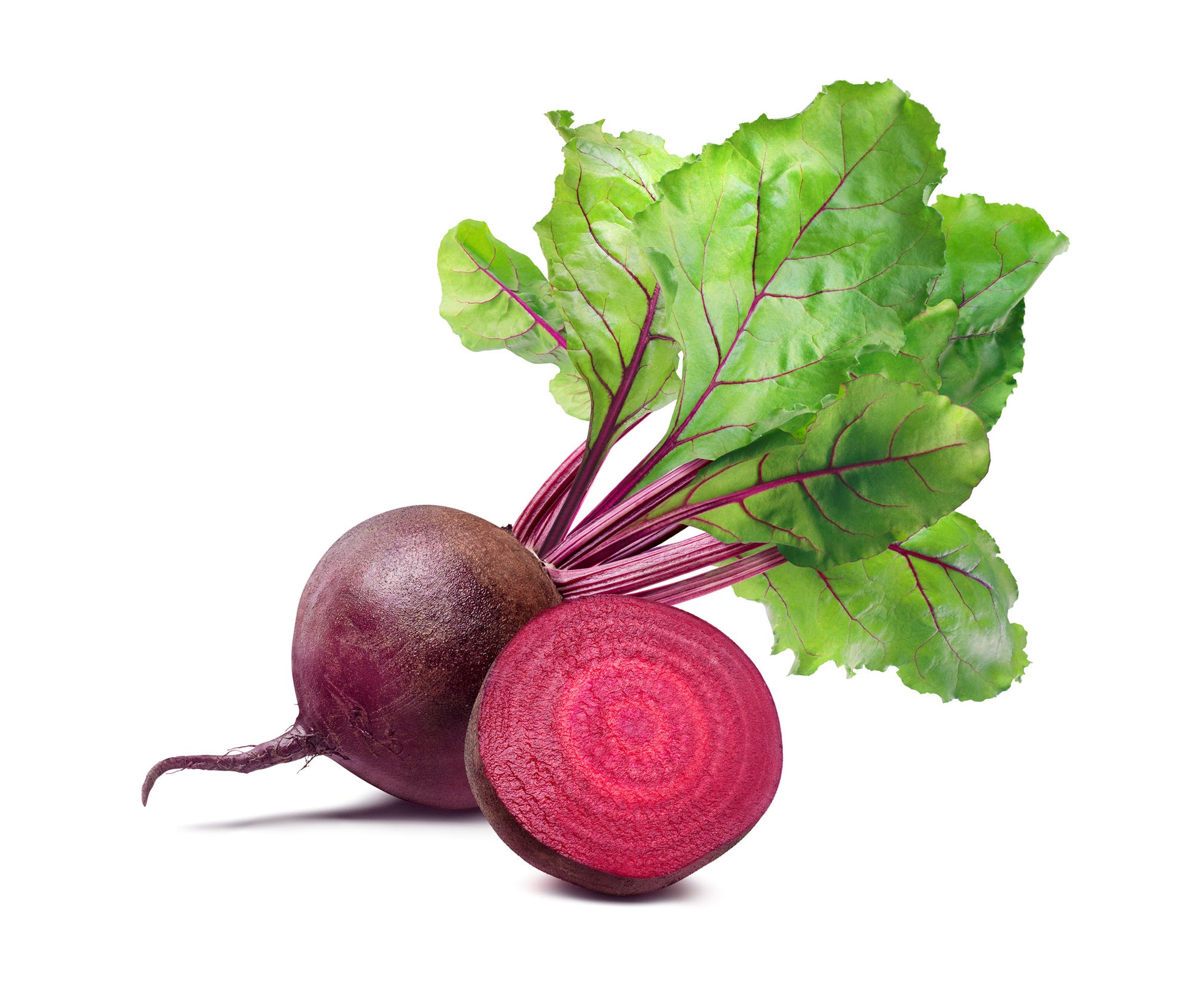 On display are 2 beets, of the variety Detroit Dark Red, laying on a white surface, surrounded with a white background.  One beet is partially in front of the other beet.  The beet in front is cut in half, displaying the red juiciness of the beet flesh. The beet in the back is intact, with the stem and leaves also intact.